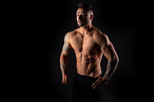 Handsome muscular male bodybuilder on a black background. Strong man.