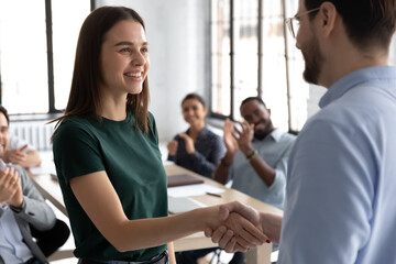Close up executive shaking successful businesswoman hand at meeting, diverse colleagues applauding, team leader thanking worker for good work result, achievement, congratulating with promotion - obrazy, fototapety, plakaty