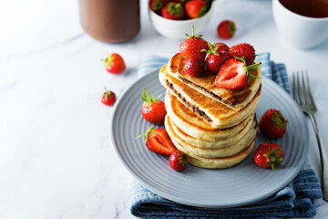 Pancakes with chocolate nutella filling decorated with strawberries
