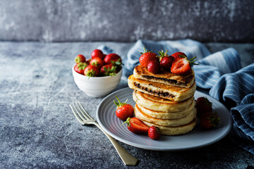 Pancakes with chocolate nutella filling decorated with strawberries