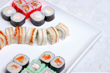 set of different types of sushi on a white plate
