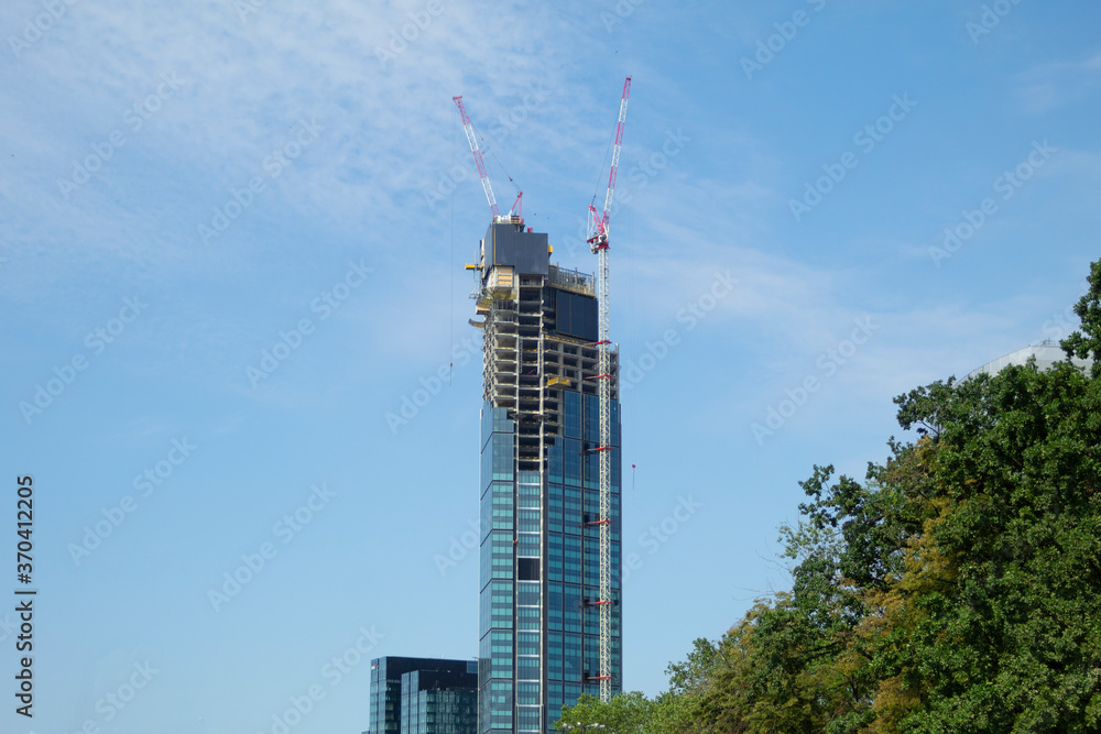 Wall mural construction of a skyscraper and two construction cranes