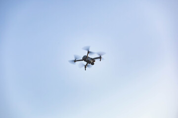 Fototapeta na wymiar Drone flying in the air with blue sky in the background. Outdoor photo
