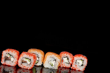 Philadelphia roll with salmon, cheese and cucumber on a black background with reflection. Sushi Philadelphia