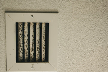 Subjective focus on lint and dirt particles on a ceiling air vent