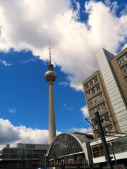 Der Berliner Fernsehturm und der Bahnhof am Alexanderplatz mit blauem Himmel und weißen Wolken in...