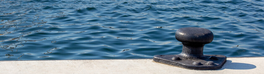 Fototapeta na wymiar bollar on pier with blue sea water in background