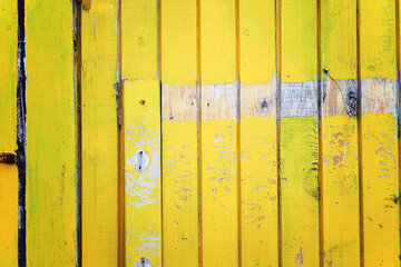 Wood texture from yellow painted planks with scratches and scuffs.