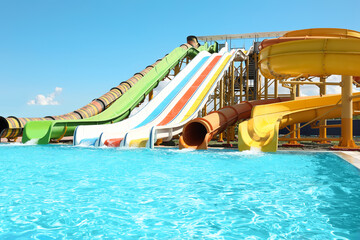 Different colorful slides in water park on sunny day