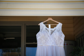 Wedding dress hanging from back porch of farm house on wedding day