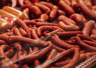 A large number of sausages in the meat market. Variety of choice of meat products. Sausage sale.
