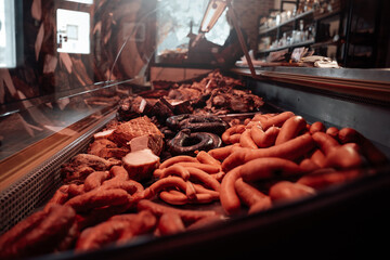 Many sausages in the butcher shop. Smoked meat assortment with huge choise. Sausage sale.