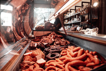 Huge assortment of sausages in a shop window. Different fresh and deli sausages in a single store....
