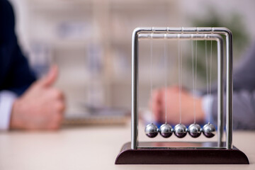 Two businessmen and meditation balls on the table