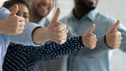 Close up diverse employees showing thumbs up together, team building, happy overjoyed colleagues recommending best corporate service, good career opportunities, human resources and employment concept