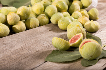 Green Figs, cut slices and leaves on old wooden table
