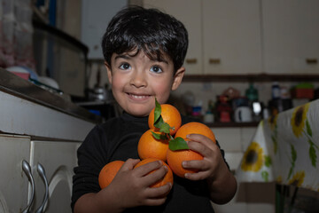3 year old boy with oranges in his arms
