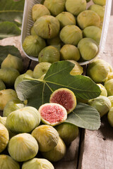 Green Figs, cut slices and leaves on old wooden table