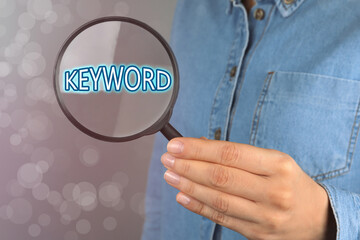 Woman demonstrating word Keyword through magnifying glass, closeup