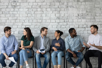 Young diverse candidates chatting, talking while waiting for job interview, friendly applicants...