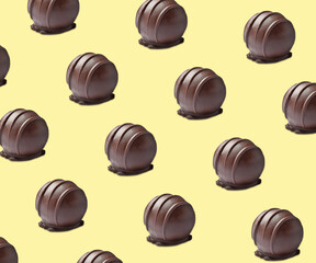 Tasty chocolate candies on pale yellow background. Pattern design