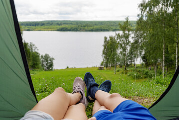 children boy and girl in camping tent  on the river bank in a picturesque landscape