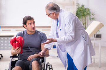 Young injured boxer visiting old doctor traumatologist