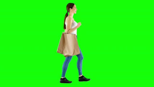 Young Cheerful Girl Walks With Shopping Bags Hanging Off Her Arm Green Screen