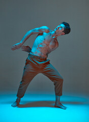 Cool young guy dancer dancing expressive dance without shirt in neon light. Dance school poster