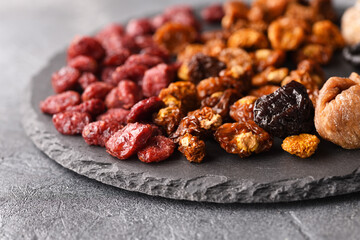 Dried fruits on a slate plate on a background.
