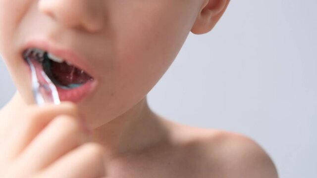 boy, kid 6-7 years old diligently brushes teeth and colored children's paste, dental concept, oral hygiene, daily morning routine