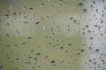 Close-up of glass with raindrops on natural background, drops of water on car glass, selective focus