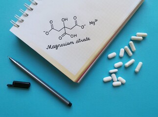 Structural chemical formula of magnesium citrate molecule with white pills. Magnesium citrate is a...