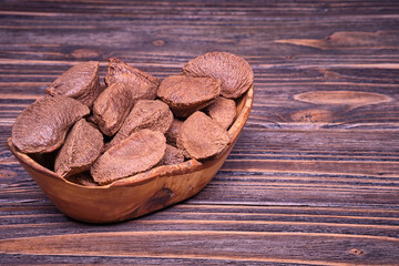 Paranuts in an olive wood cup, vegetarian food in wooden bowls.