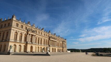 Obraz premium Château de Versailles côté jardin, vue sur la façade du corps central du palais royal et sa terrasse, sous un ciel bleu (France)