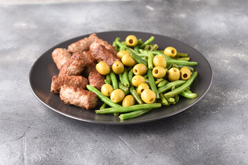 Bean pods, olive and fried Turkish cutlets.