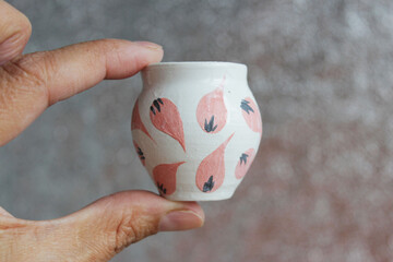 small handmade white clay pot for making wishes or flowers from boutonnieres. Decor engobe, covered with transparent glaze, two firing