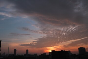 東京の街の夜明けと建物のシルエット茜色に染まる空