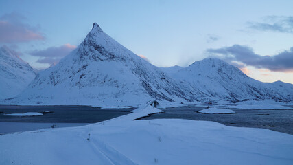 Cold snow winter landscapes with dominant Volandstind Peak during sunset at Fredvang, Lofoten,...