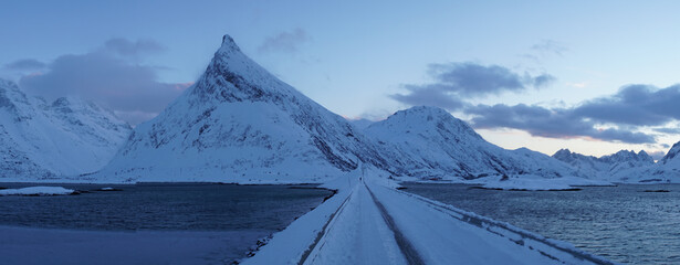 Cold snow winter landscapes with dominant Volandstind Peak during sunset at Fredvang, Lofoten, Norway.