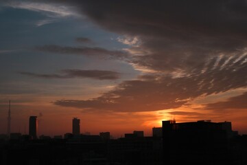 Fototapeta na wymiar 東京の街の夜明けと建物のシルエット茜色に染まる空