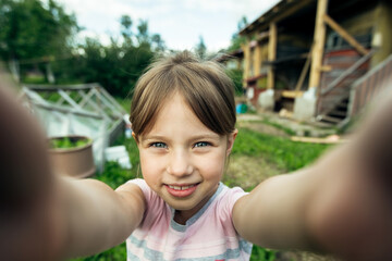 Little cute girl funny taking a selfie out in the viilage house.