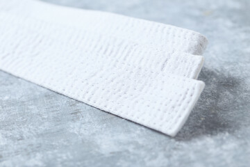 White karate belt on rustic wooden background. Close up. Copy space.  © Eugeniusz Dudziński