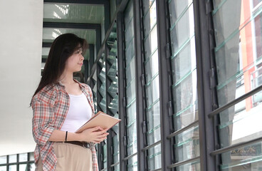 Woman standing and looking out the windows