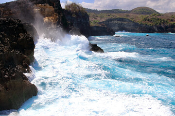 Indic sea waves hitting the cliff rocks at Angel’s Billabong point, an amazing spot close to Broken beach in Nusa Penida Island, Indonesia.