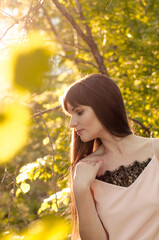 Naklejka premium Attractive young woman outside in park with sunset in background