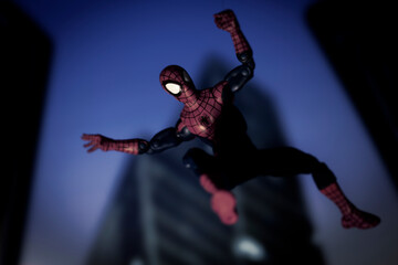Obraz premium NEW YORK USA - AUGUST 9 2020: Marvel comics superhero Spiderman swinging from a web at night - Hasbro action figure