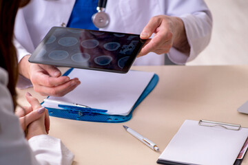 Old male doctor radiologist and his young female assistant in th