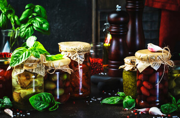 Canned food concept. Fermented, pickled, marinated preserved vegetarian italian snacks and sauces. Organic sun-dried tomatoes, artichokes, capers, olives, marinara sauces, pesto in jars with spice 