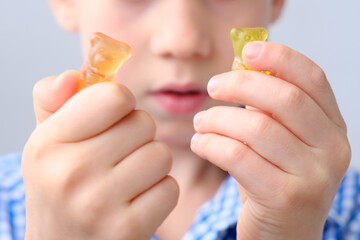 boy, kid holding sweets in his hands, gummy bear, concept of children's delicacy, healthy and...